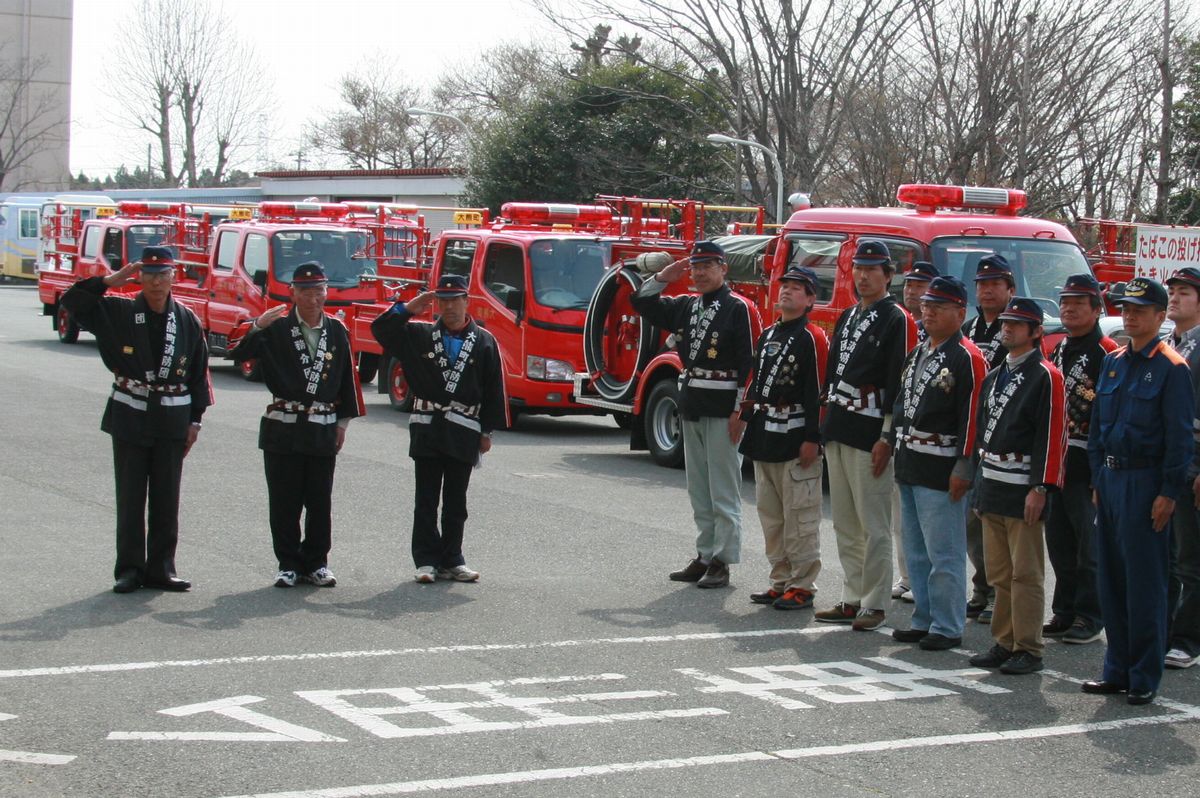 出発式で敬礼する消防団員