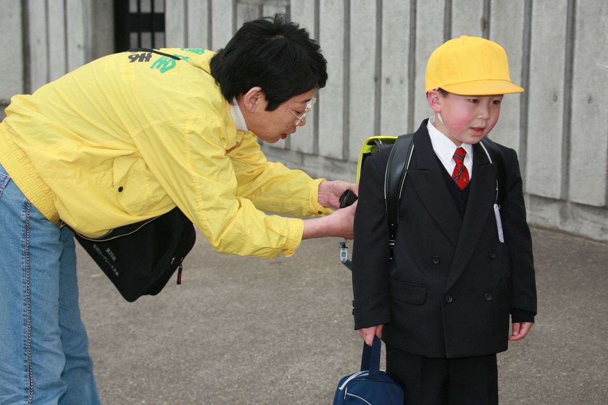 「入学おめでとう。交通事故に気をつけてね」と新1年生に話す会員