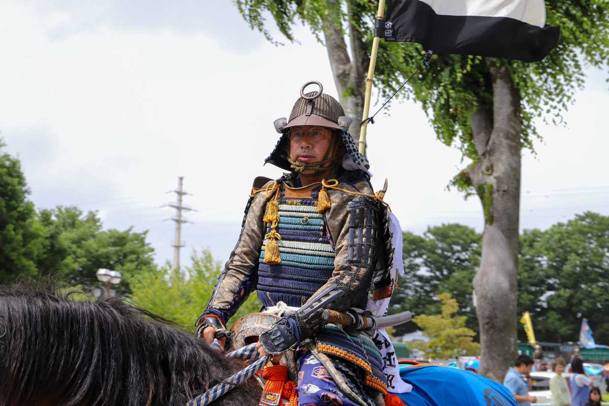 お行列で行進する御神輿守護役の小野田さん