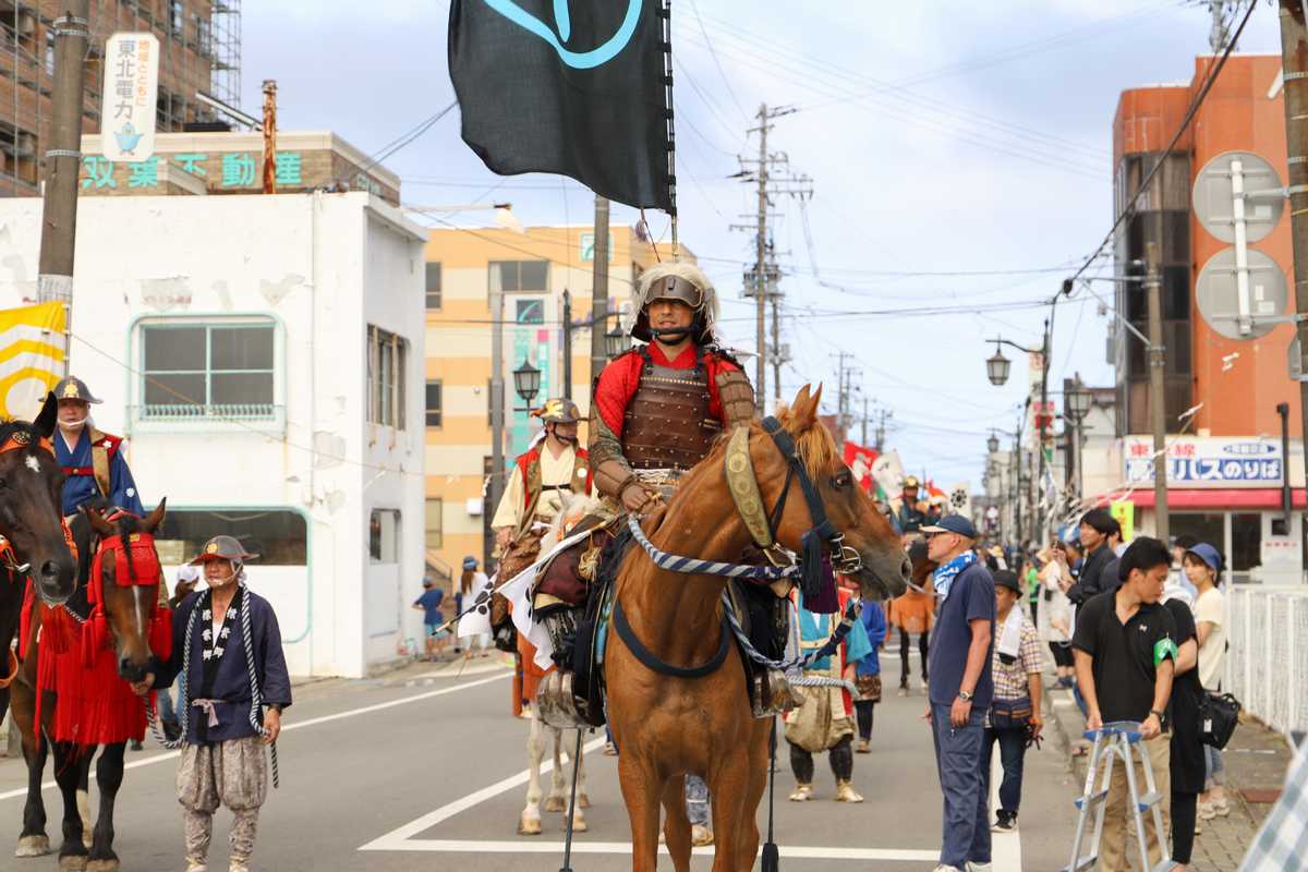 浪江駅前を行進する吉田さん