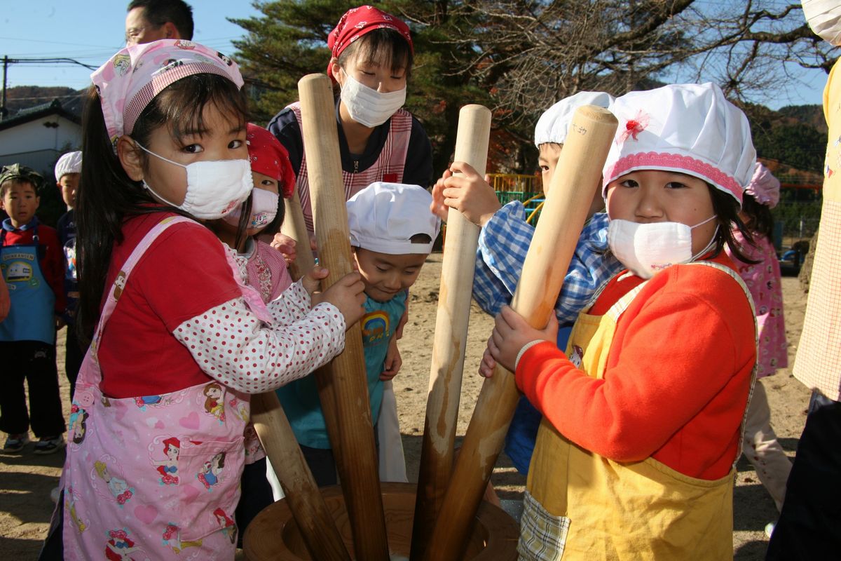 細長い杵を1本ずつ持ってもちをつく園児たち