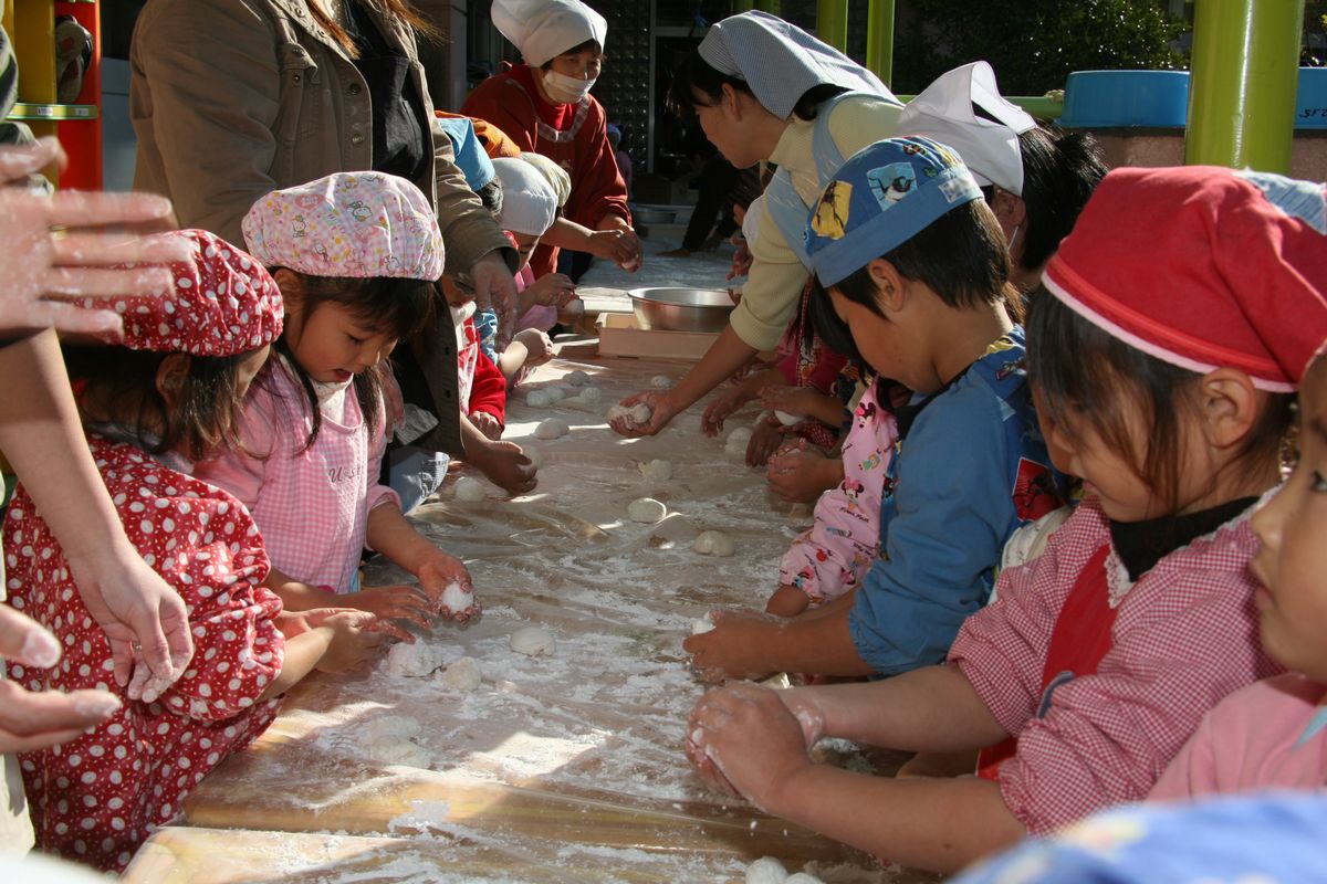 つきたての餅を食べやすい大きさにちぎって、丸く整える園児たち