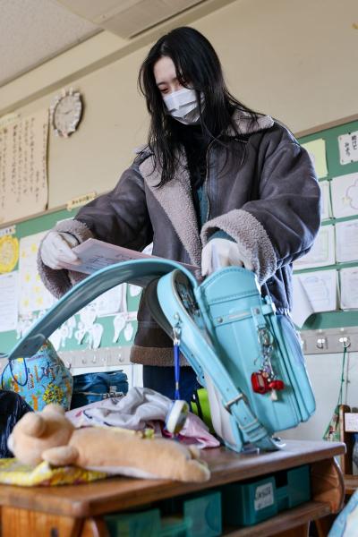 2月、東日本大震災後初めて熊町小学校、熊町幼稚園、熊町児童館が私物の持ち出しのため開放されました。3施設は避難指示区域内にあるため容易に立ち入りができませんでした。熊町小学校では、約13年ぶりに母校へ登校した当時の在校生が、校舎に残したままだったランドセルと再会。中に入っていた学用品を一つずつ手に取って確かめました。