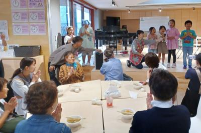 町立学び舎ゆめの森と町社会福祉協議会は10月18日、芋煮会を開催しました。子どもたちと地域住民の交流を深めるために企画されたもので、昨年に続き2回目です。写真は出来上がったごちそうを前に、1年生が元気よく「いただきます」のあいさつをする様子。