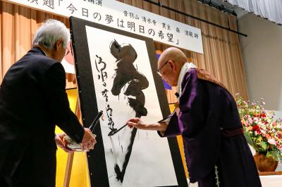 11月1日で町制施行70周年を迎えた大熊町で7日記念式典が開かれ、町交流施設linkる大熊の会場には多くの関係者が出席しました。終了後には音羽山清水寺の森清範（もりせいはん）貫主による記念講演が行われ、演題の一文字「夢」を揮毫し70周年を迎えた大熊町を祝いました。