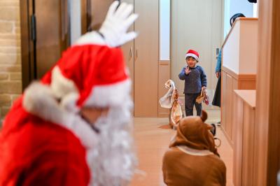 自宅に来訪したサンタに手を振る子ども