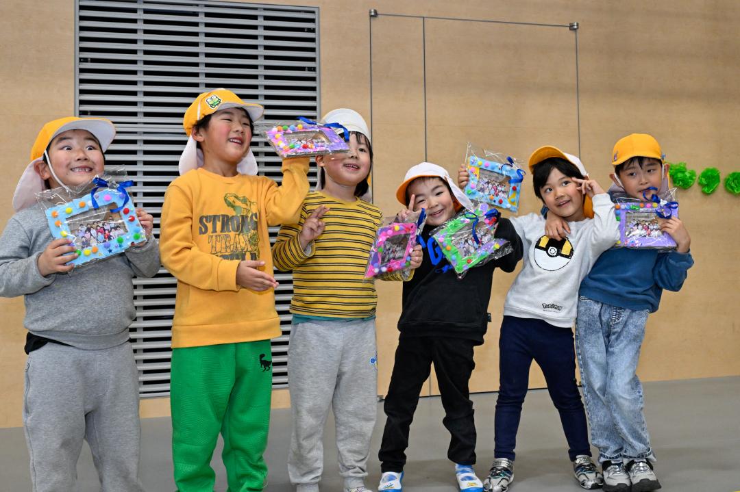 プレゼントの集合写真を手にした園児ら