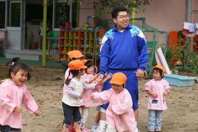 幼稚園に職場体験に訪れ、園庭で園児と遊ぶ生徒