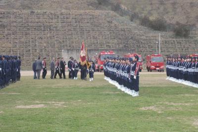 大熊中学校グラウンドで通常点検を受ける消防団員136人と婦人消防隊員64人